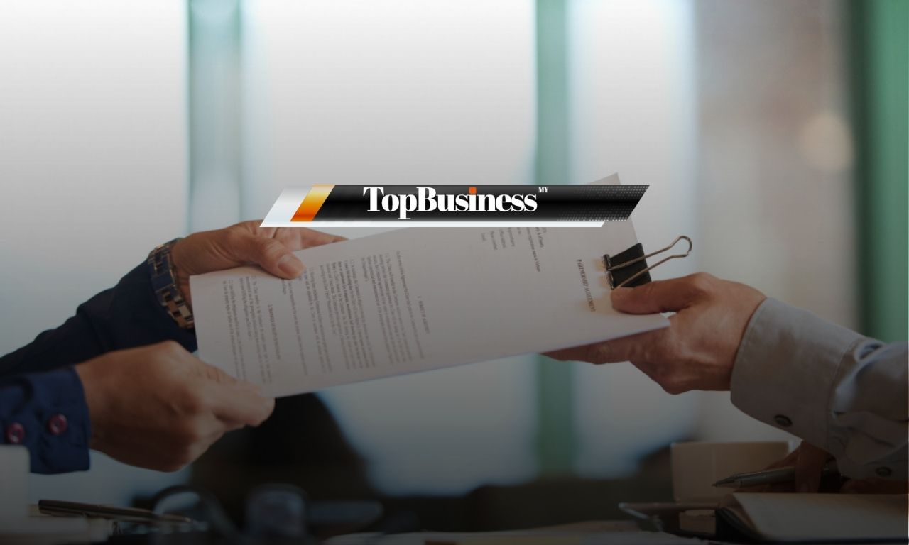Photo of a boss handing over a probation letter or contract to an employee, during a probation period in Malaysia.